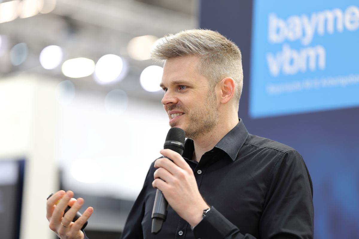 Dr. Jonathan Mall mit Mikrofon in Nahaufnahme beim bayme vbm Kongress